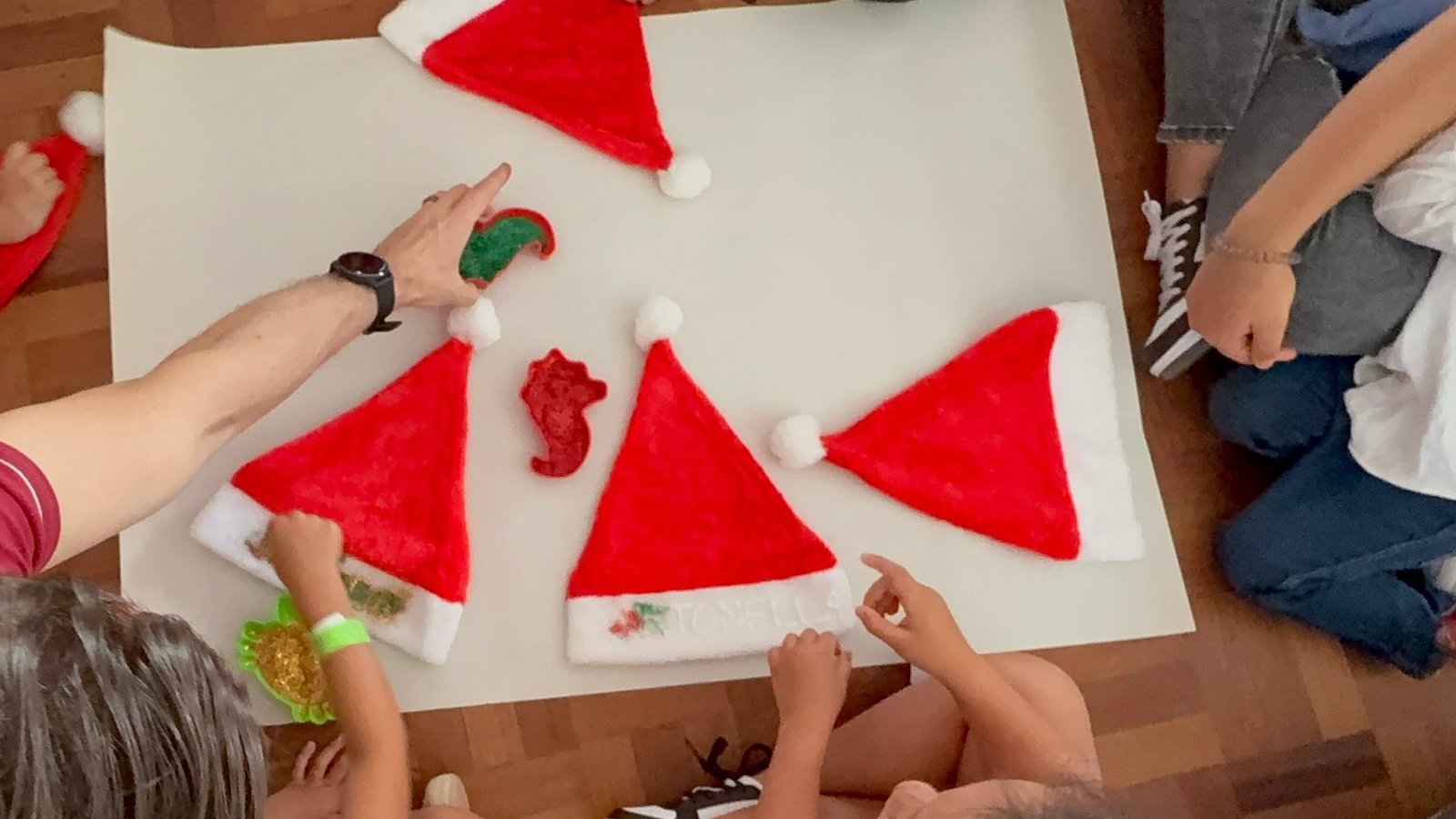 Kids decorating Santa hats with glitter at one of the December camps in Medellín, seen from above